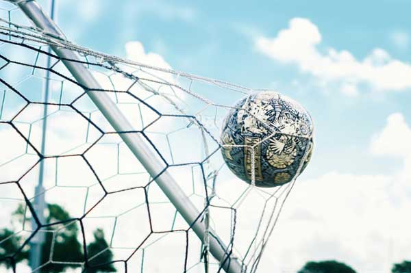 Soccer ball hitting the net in a goal. 