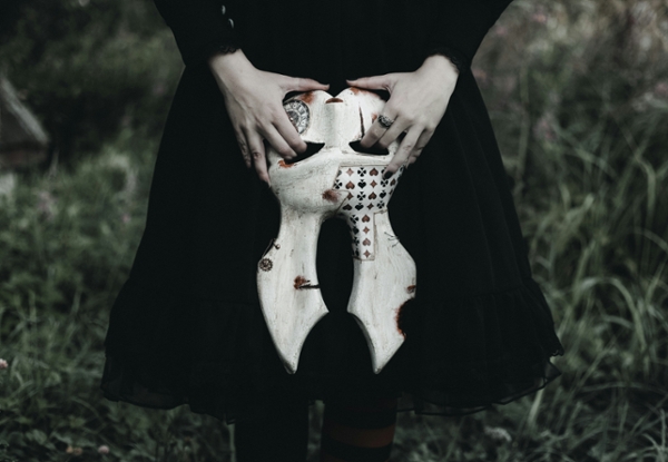 Person holding a gothic white rabbit mask. 