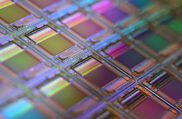 Macro photo of a silicon wafer. Each square is a chip with microscopic transistors and circuits.