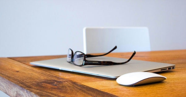 Glasses sitting on a computer desktop. 