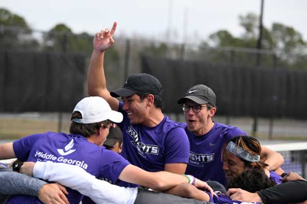 Men's tennis celebrates a win on the court.
