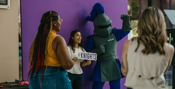 Students take photos with Duke at a photobooth.