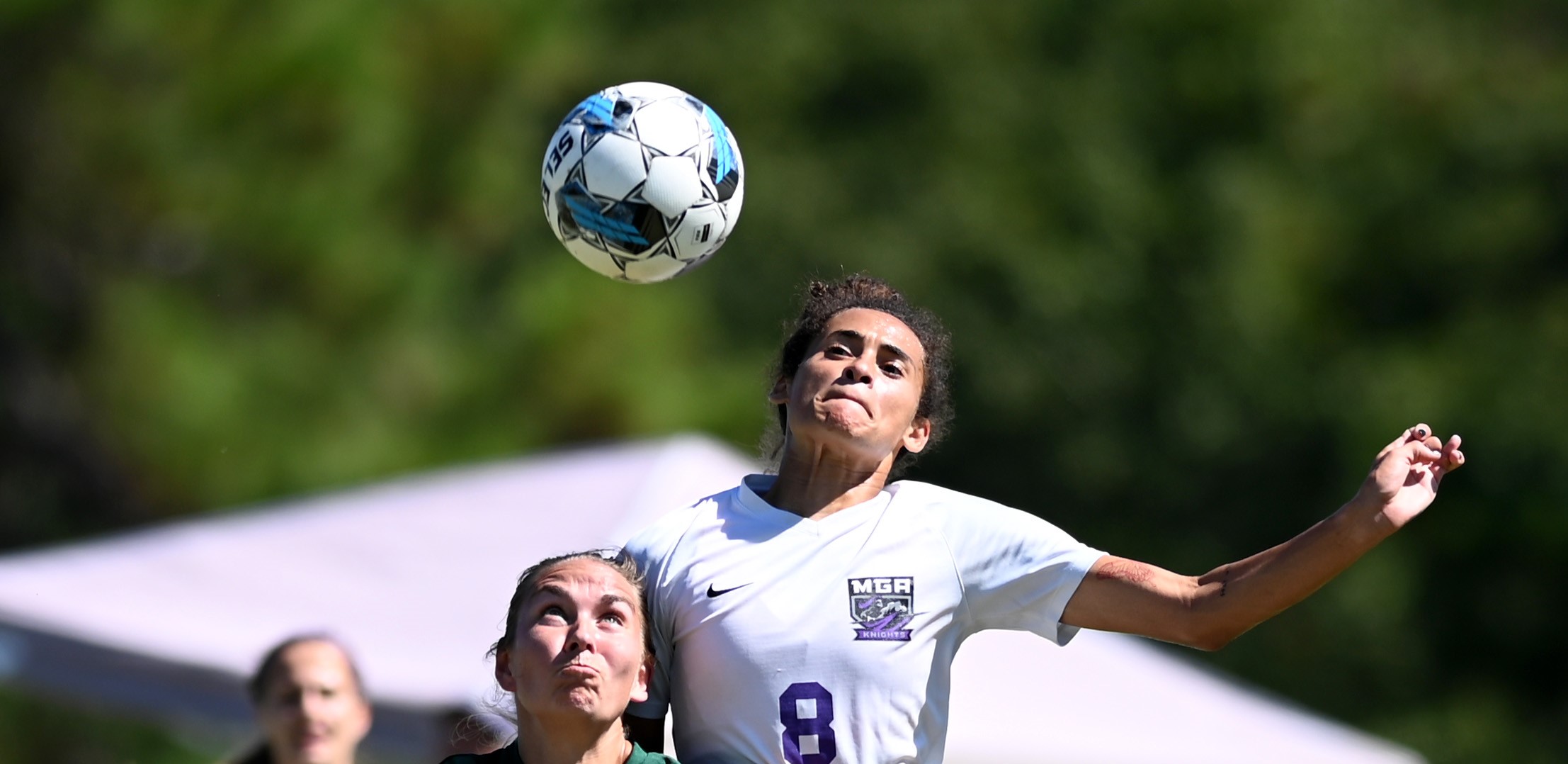 Knights women's soccer player headbutts the ball. 