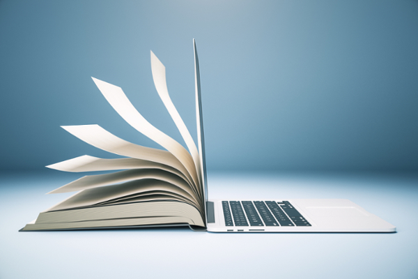 Open book and open laptop open, spine-to-spine.