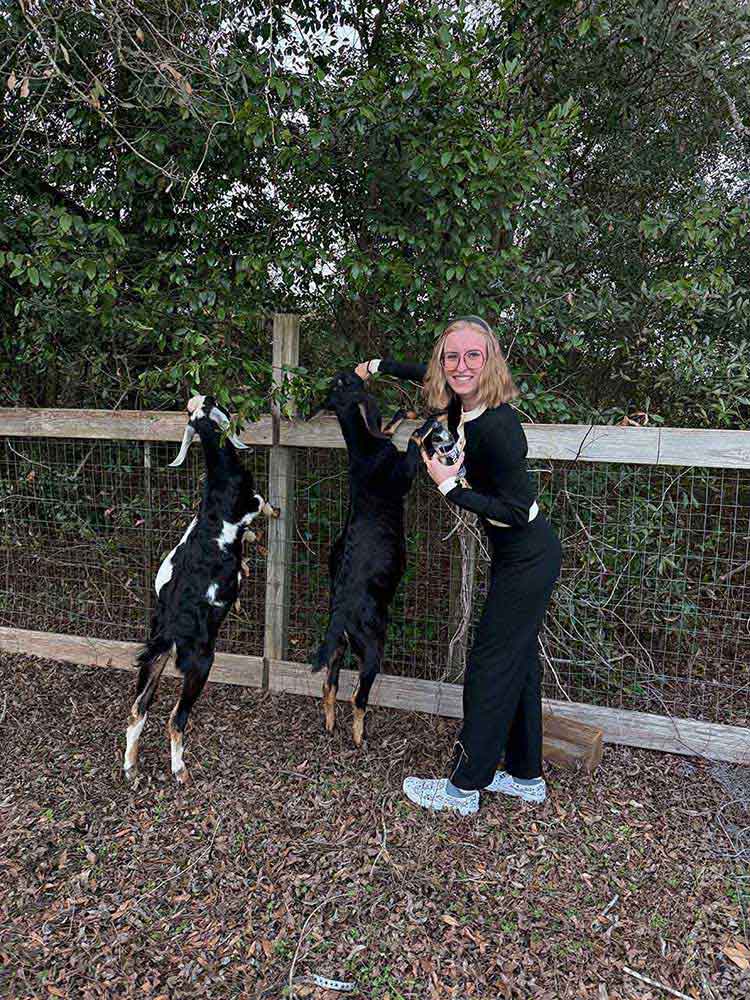 Manon Cerri plays with goats on a farm in Plains, Ga. 