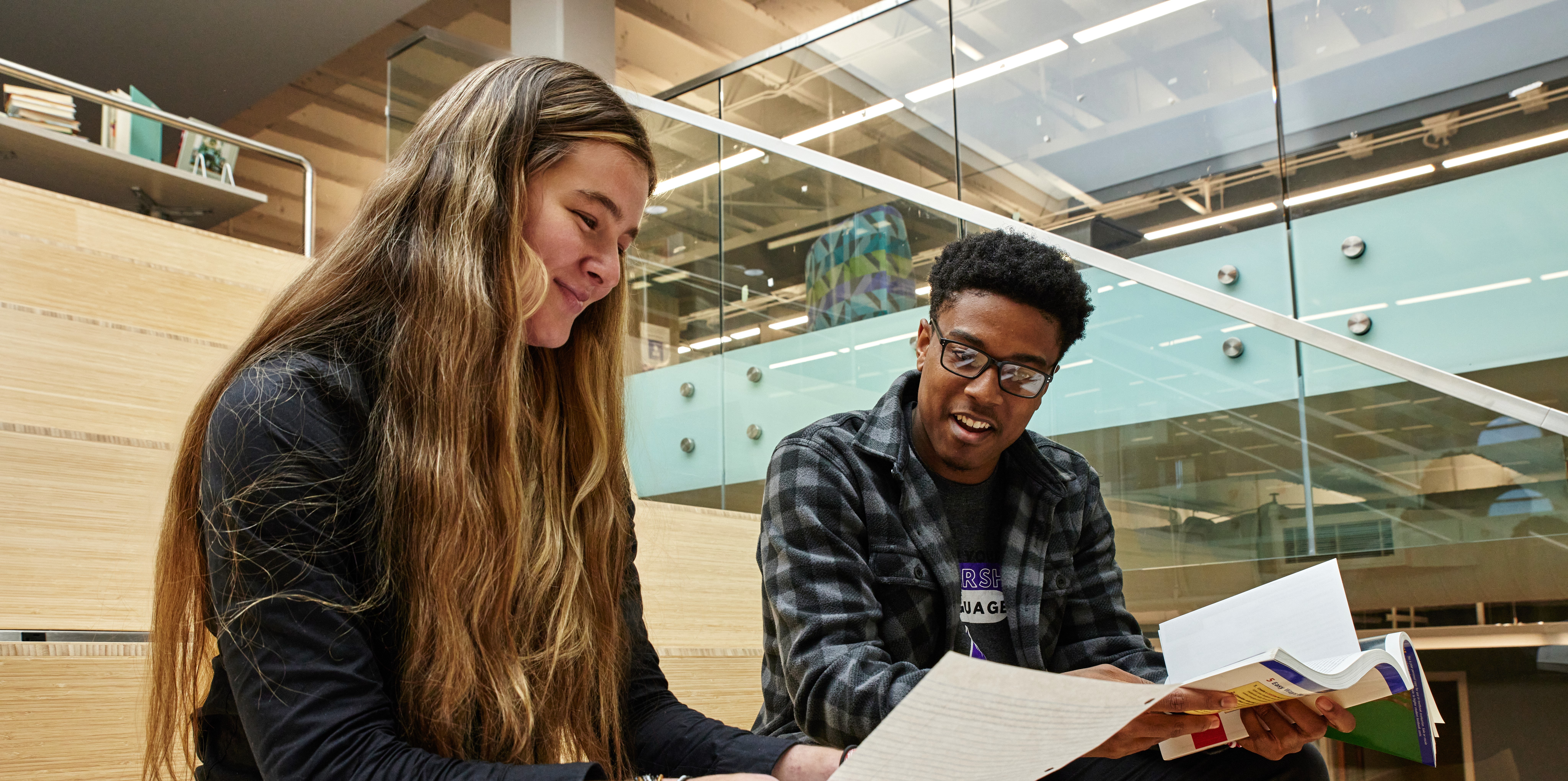 Two students study on the stairs in the Roberts Memorial Library. 