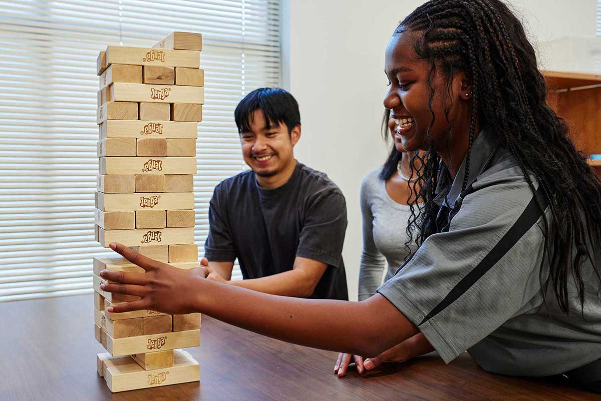 Male and female students playing Giant Jenga.