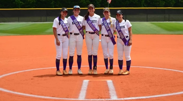 Senior Knights softball players pose on the mound.