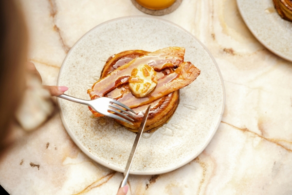 Person cutting pancakes with a fork and knife.