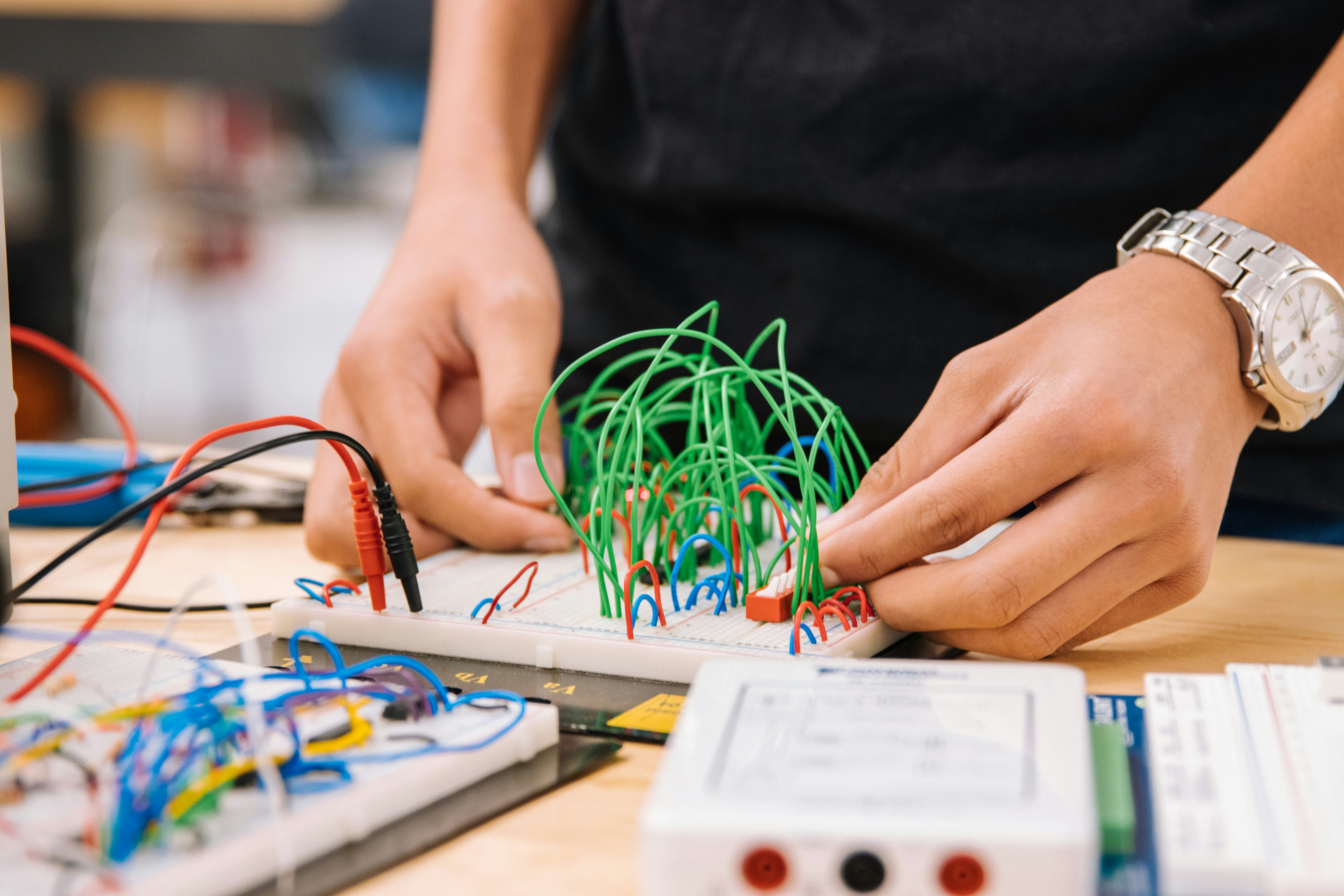 Person playing with a circuit board of wires. 