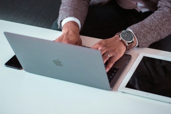 Person types on a laptop at a desk.