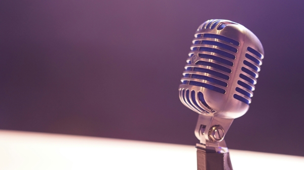 Condenser microphone against black backdrop.