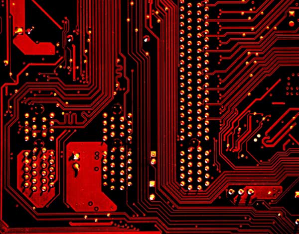 Circuit board lit up by red neon lights. 