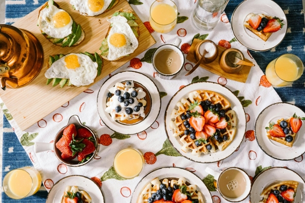 Flat lay of breakfast food, including berries and waffles.