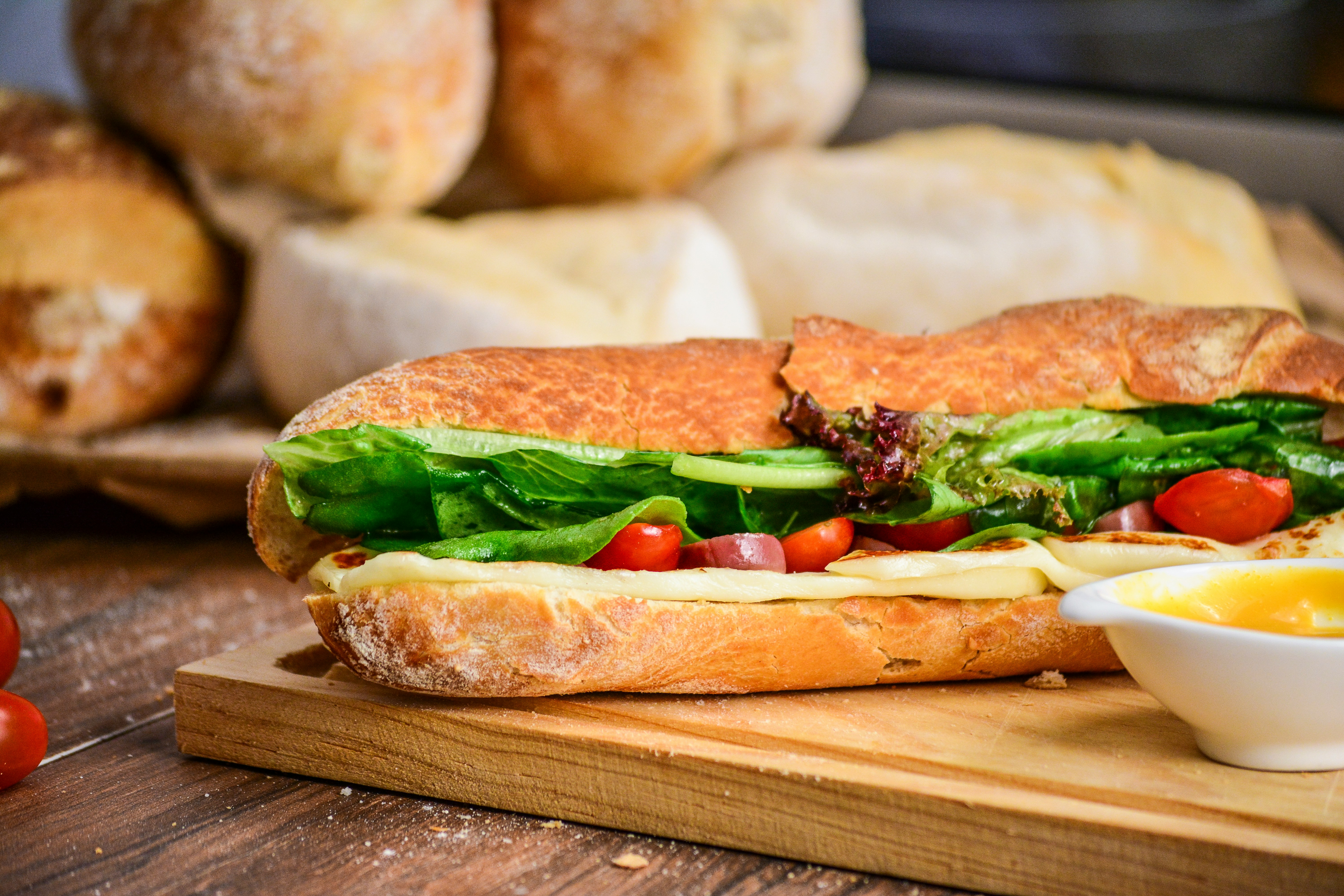 Sub sandwich rests on a wooden chopping block. 