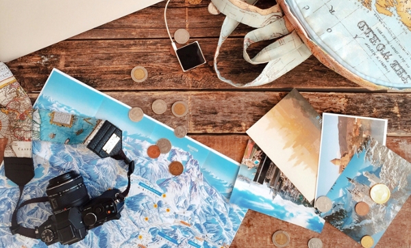 Backpack, photos, map, camera, and iPod sit on a desk.