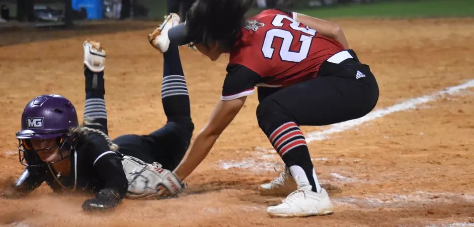 Knights softball player slides to a base during a game.