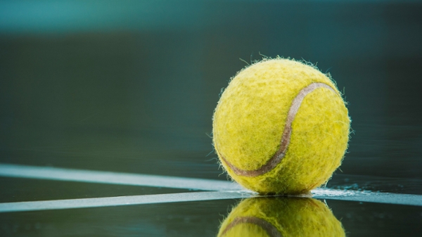 Tennis ball sits on a court.