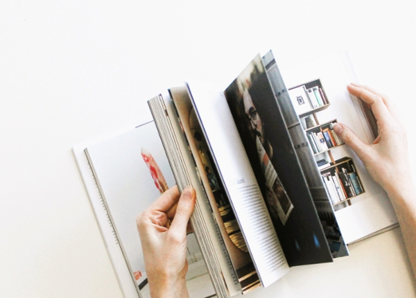 Hands flip through magazine pages.