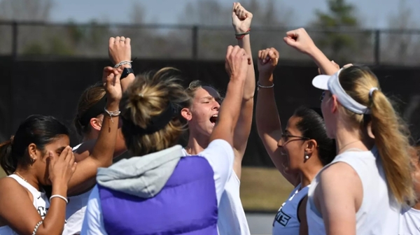 Knights women's tennis celebrates a match win on the court. 