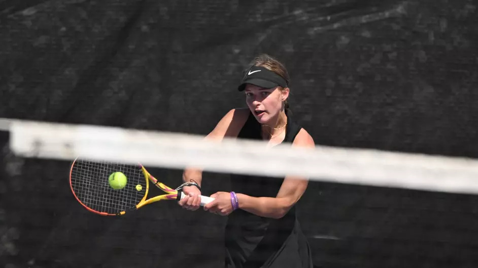 Knights women's tennis player hits the ball during a match. 