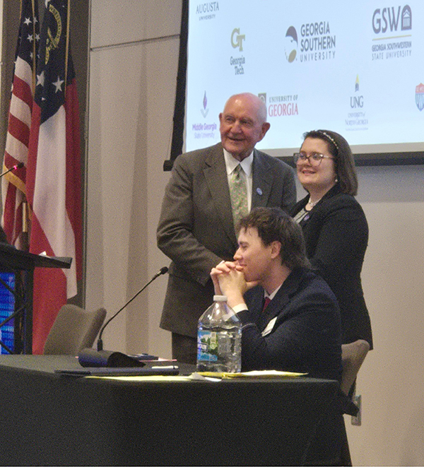 An MGA student standing at a podium with a competition official during the Regents Cup.