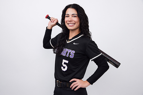 MGA student, Madison Cosgrove, posing during media day photos for softball holding up a bat.