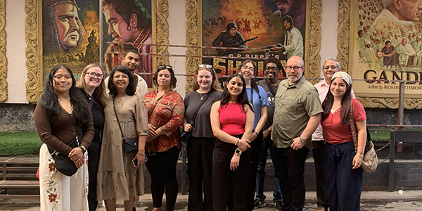 Image of a group of MGA students in front of Bollywood movie posters during their study abroad trip to India in 2026.