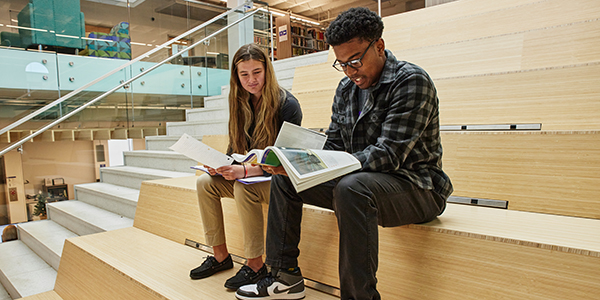 Students sitting at the Cochran Campus library steps reading together.