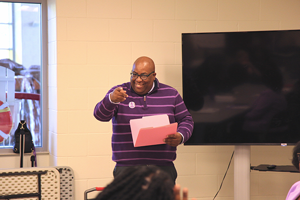 Staff council presenter smiling and pointing at an attendee of the ceremony.
