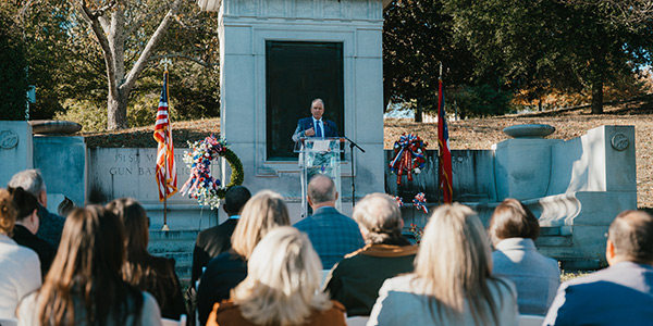 MGA President Dr. Christopher Blake addressing a seated crowd outdoors at the 2025 Veterans Day Service of Remembrance at Coleman Hill.