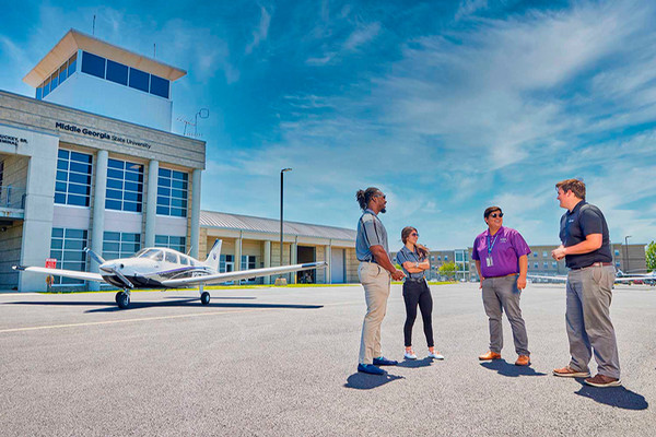 4 mga aviation employees outside control tower in eastman